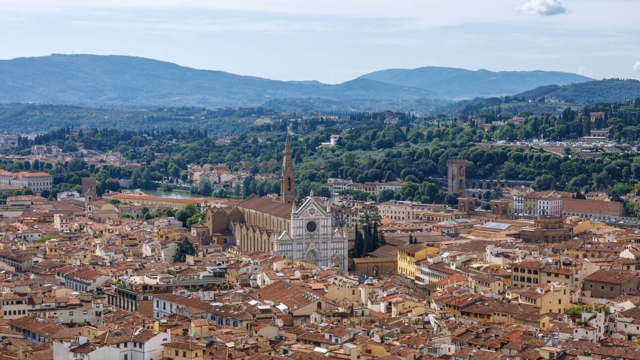 A panoramic view of Florence from the top of the Duomo’s Cupola, with the Arno River winding through the city. The perfect inspiration for a Tuscan wine getaway with Jimmy the Fox Bottle Italy Wine Travel Bag.
