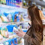 Young Business Woman In A Jacket In The Store Holding A Package