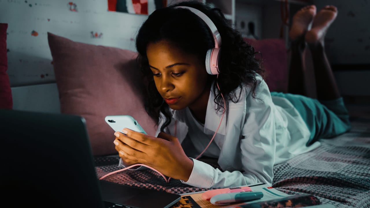 Woman laying in bed on phone
