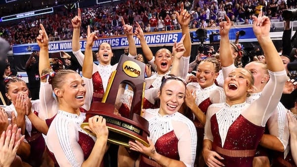 The Oklahoma Sooners react as they hold the national championship trophy during the National Collegiate Women's Gymnastics Championship 