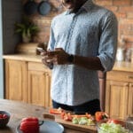 African Guy Use Cell To Search Cooking Recipe Online