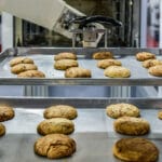 Robot Arm Preparing Cookies For The Oven In Production Line Fact