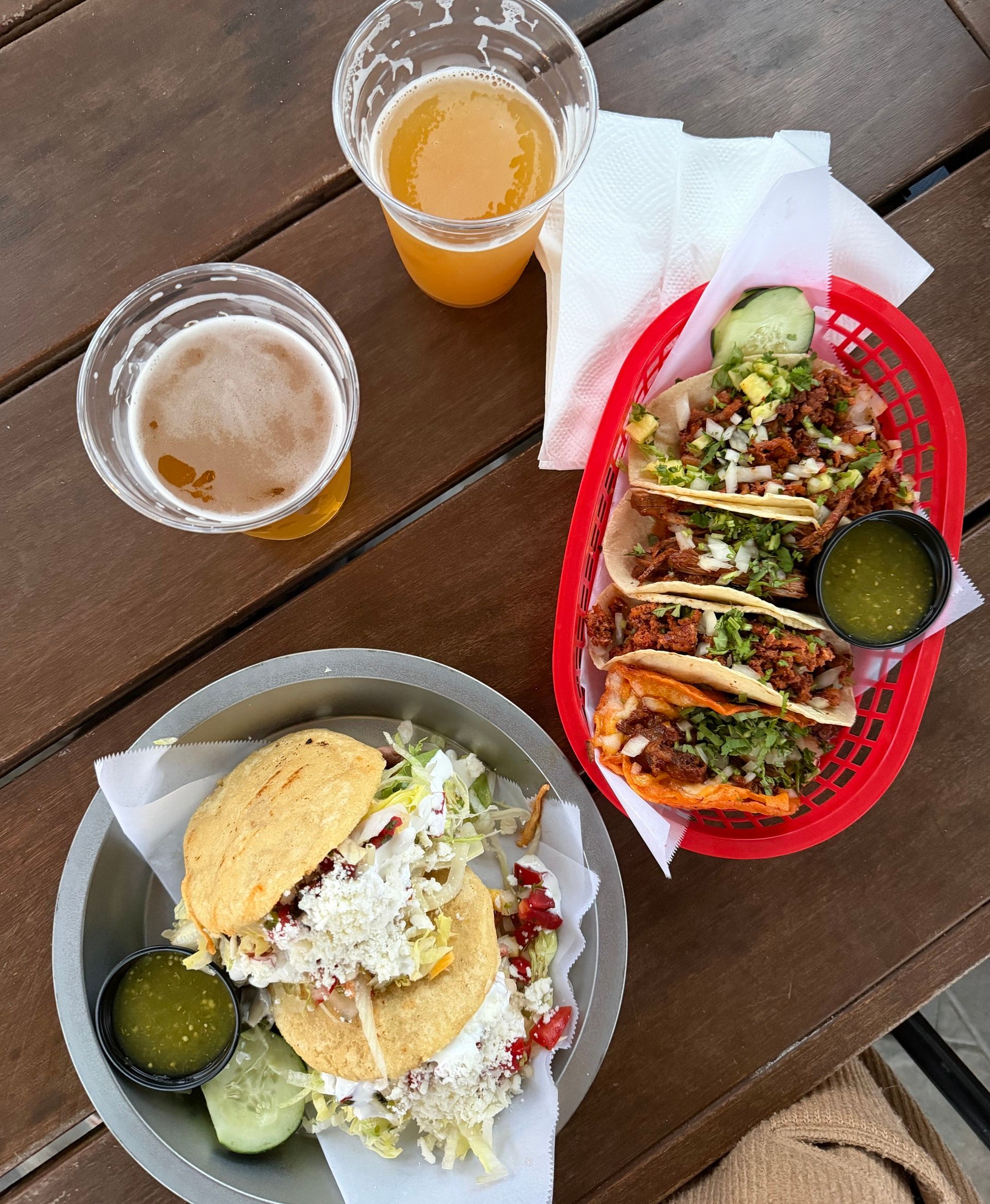Two beers, a plate of tacos, and a plate of gorditas