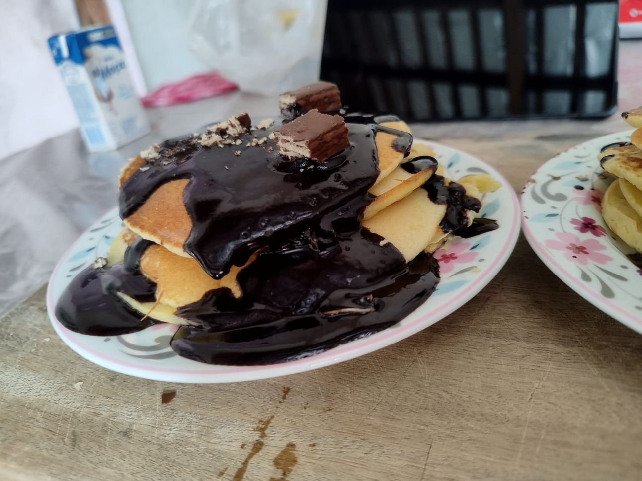 Foto linda de uma panqueca americana com calda de chocolate e bis em cima. Eu que fiz, gente! 