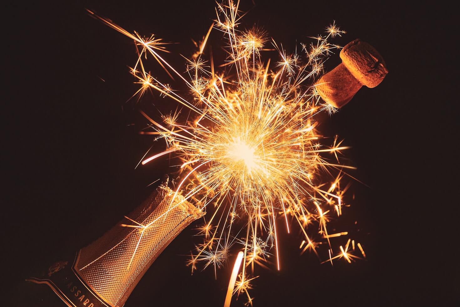 Champagne bottle with sparklers flaring from it