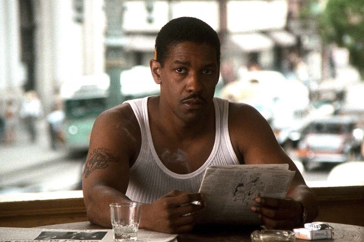Screenshot of Denzel Washington in Devil in a Blue Dress, wearing a 1940s fedora and suit in a moody noir setting.