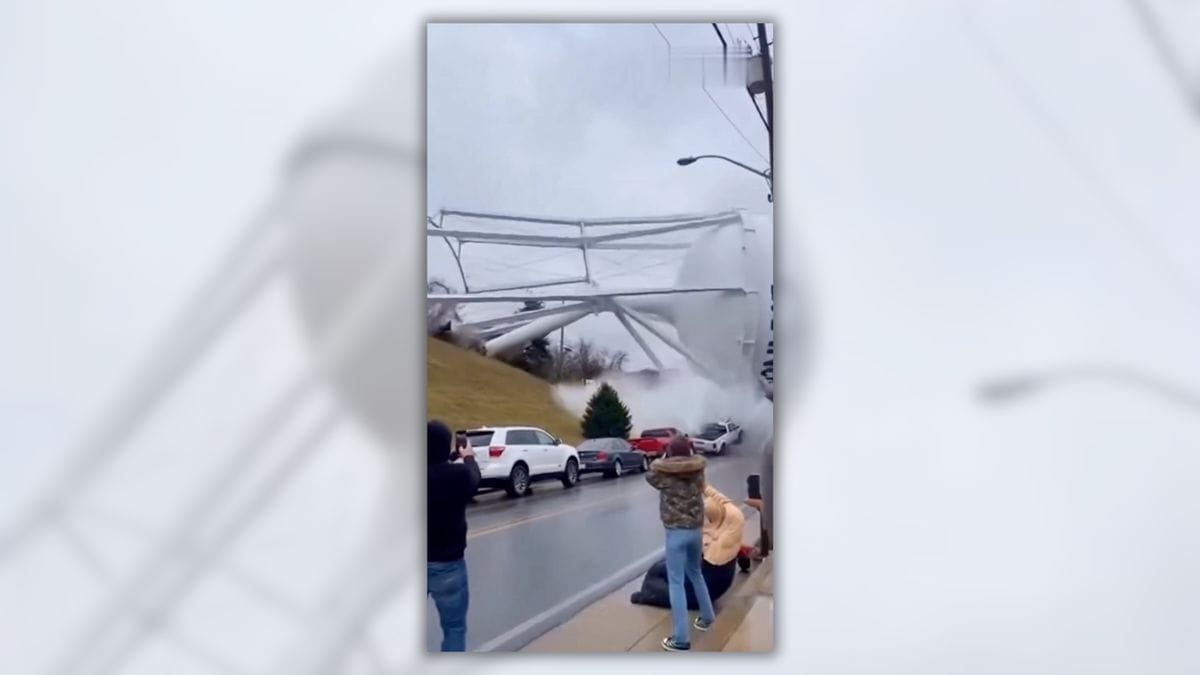 An image claims to show people watching as a water container falls over.