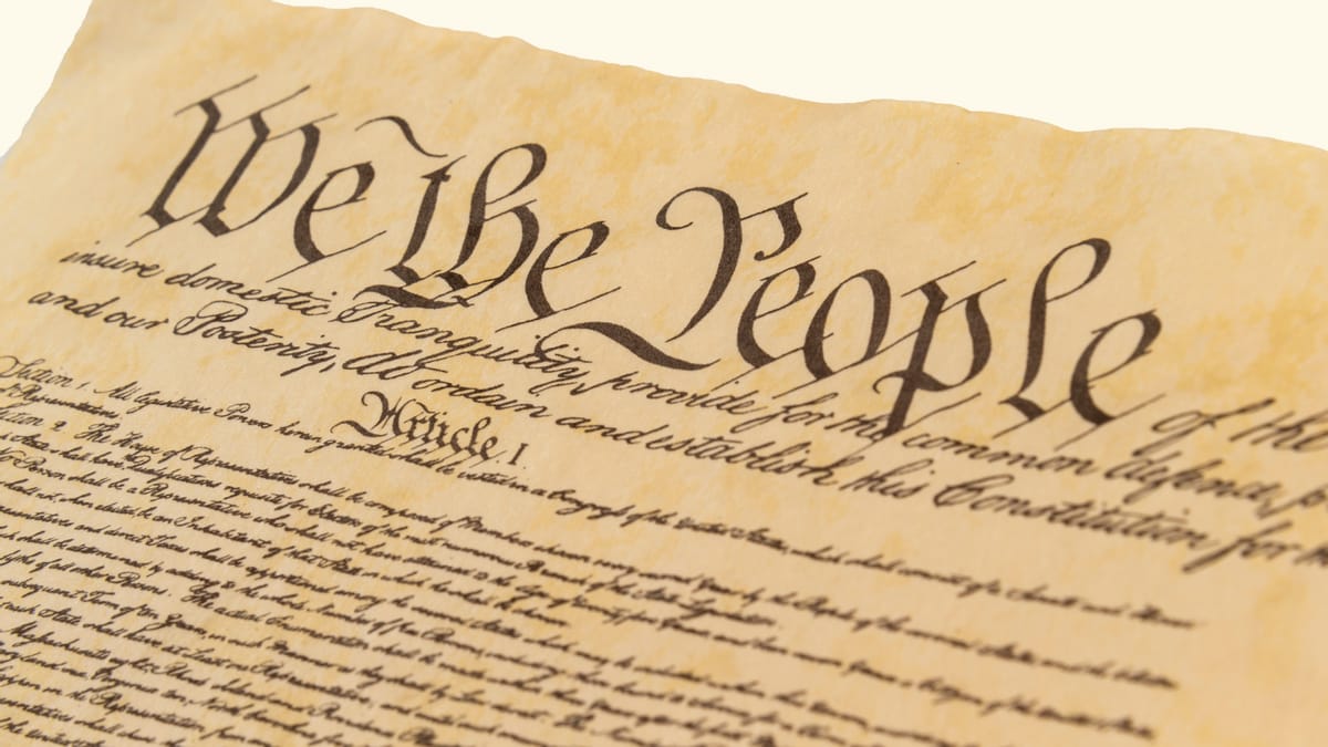 A section of a document that says "We the People" on it is shown. "Article 1" can also be seen prominently on it.