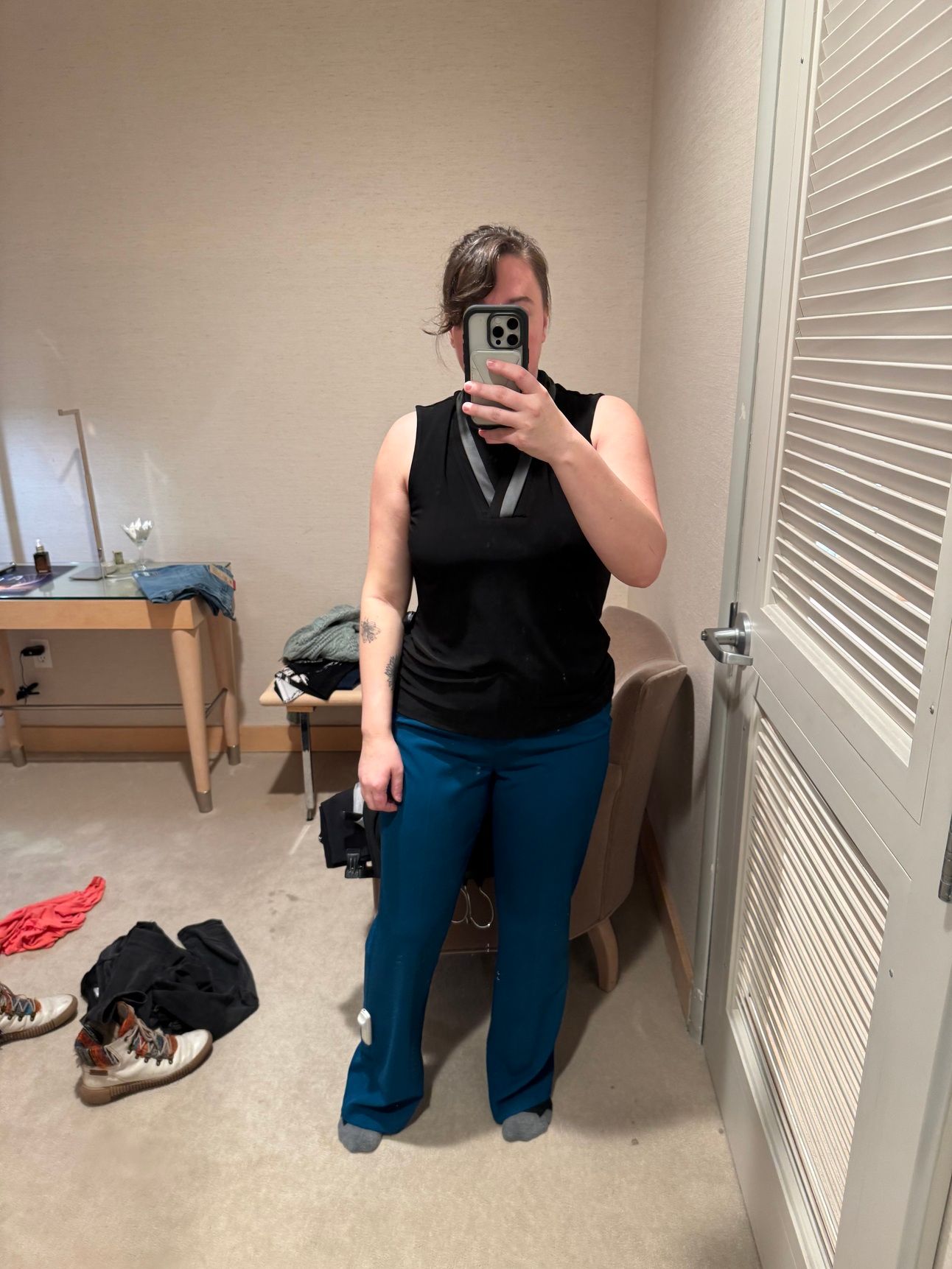 photo of a femine body in blue pants and black sleeveless blouse