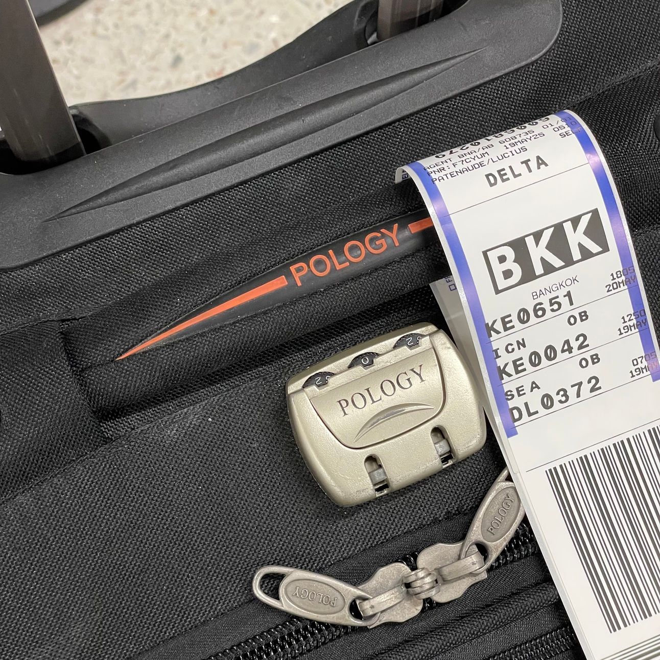 Luggage with an airplane tag with a final destination of Bangkok, Thailand.