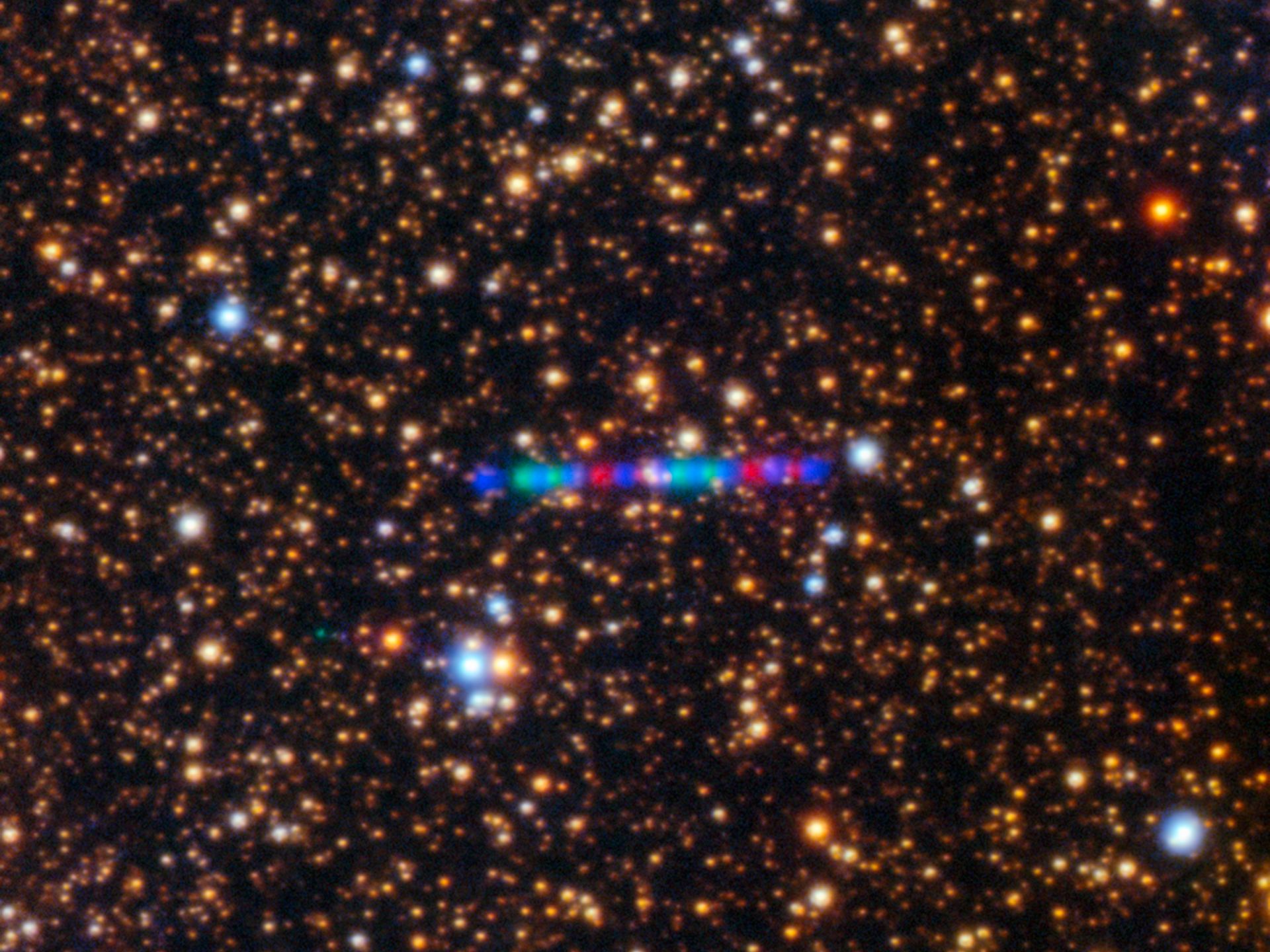 In this image from the Gemini North telescope’s Gemini Multi-Object Spectrograph (GMOS-N), Comet 3I/ATLAS appears against a dense backdrop of stars. Shown here is the comet’s vivid path through the Solar System, captured using three filters rendered in red, green, and blue.