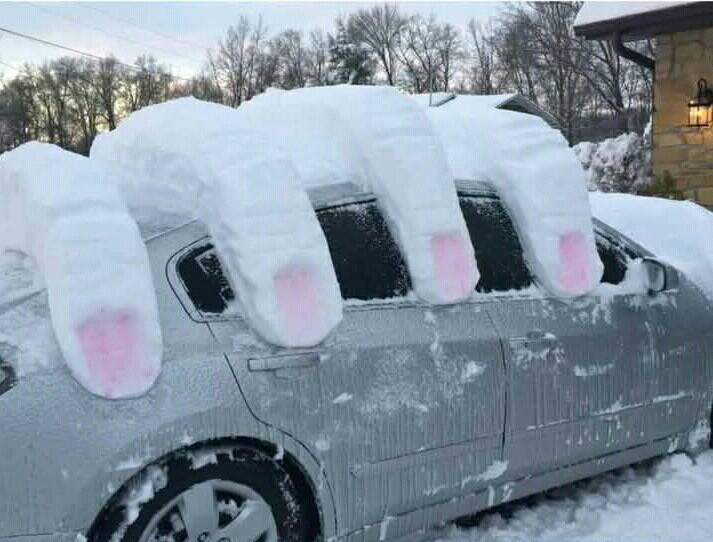 snow formed into the shape of giant fingers on top of a car