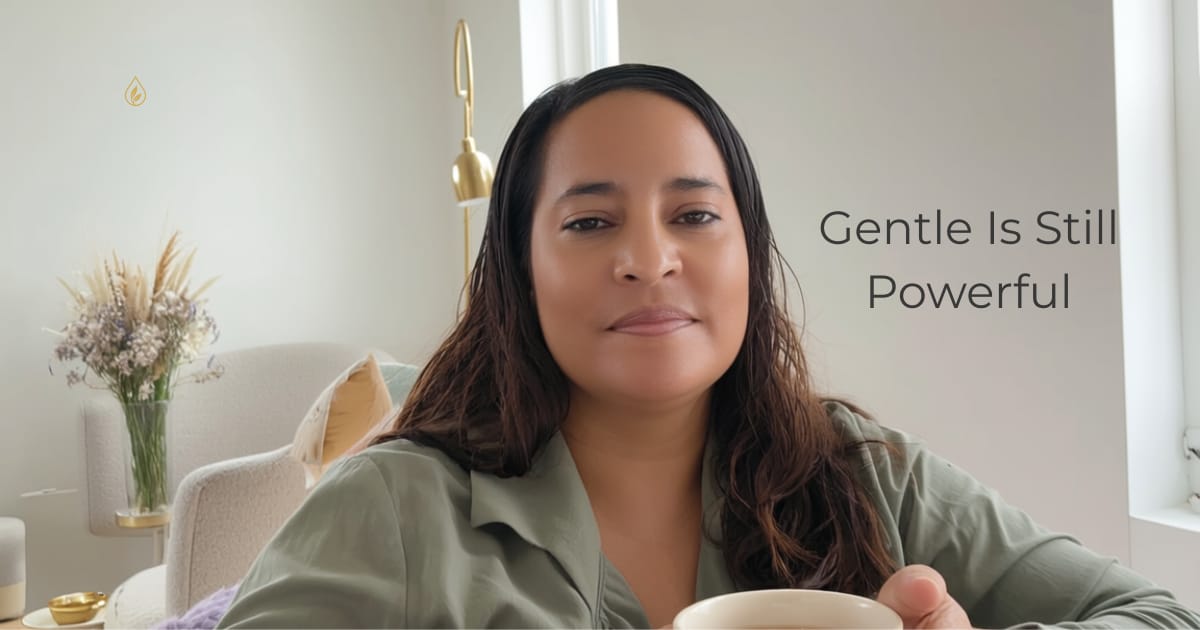 Jenice Story holding a warm cup in a softly lit space, calm expression and relaxed posture, representing gentleness, safety, and nervous system ease.