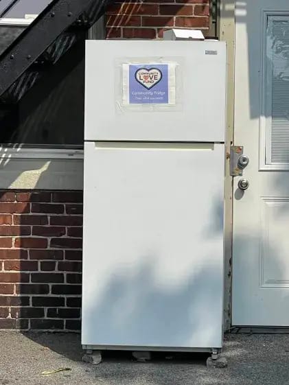 An outdoor fridge with a label that says "Community Fridge take what you need"