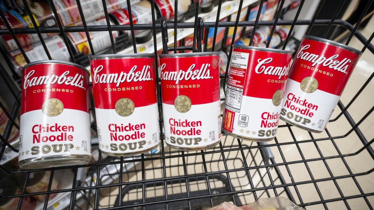 A line of Campbell's Chicken Noodle Soup cans are shown in a shopping cart.