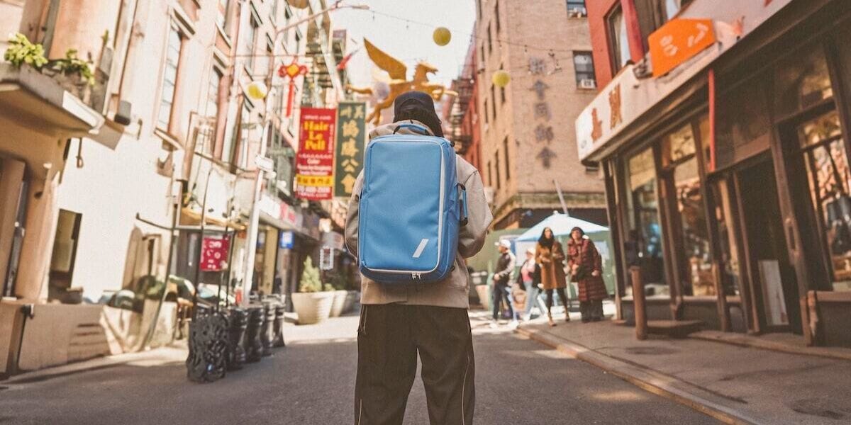a guy wearing a backpack in a city street