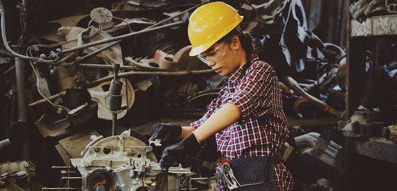 Female engineer working on an engine - highlighting women in careers, hands-on learning, and purposeful work.