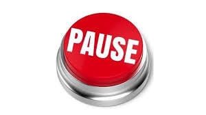 A red button with pause in white capital letters