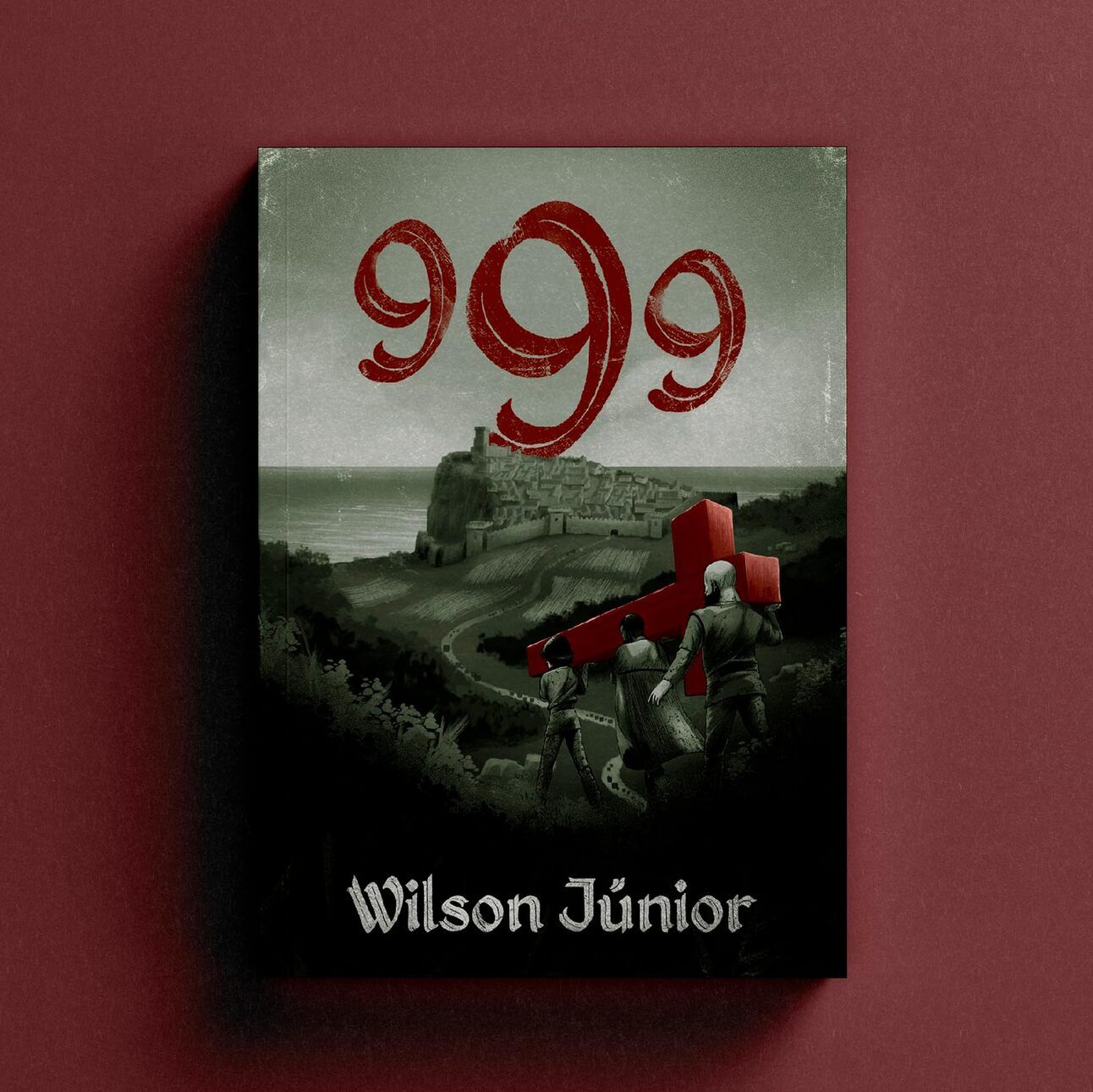 Fotografia do livro 999. A capa mostra uma ilustração em preto e branco de homens carregando uma cruz vermelha até um forte à beira do mar. O título também está em vermelho.