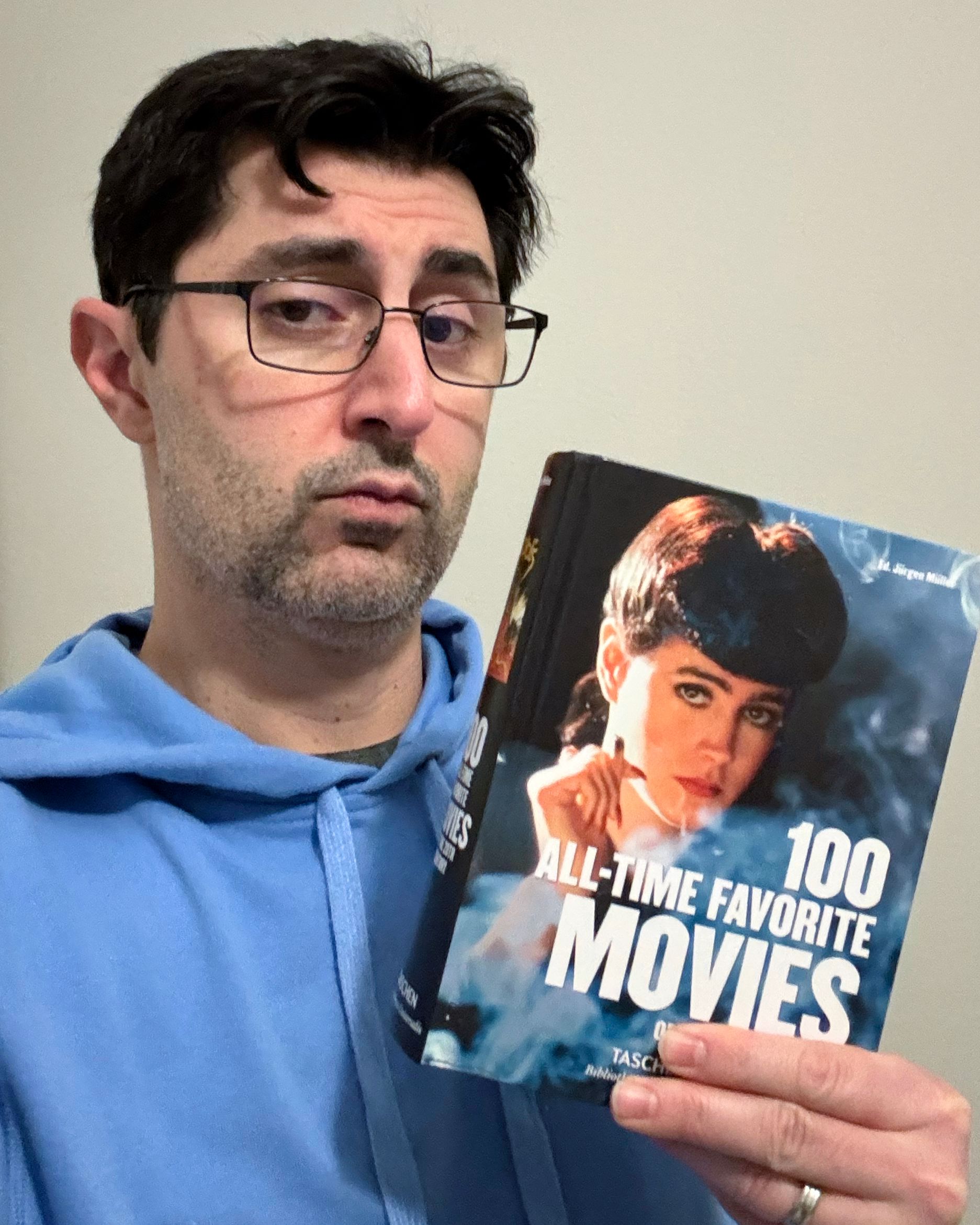 PJ holds the book, 100 All-Time Favorite Movies