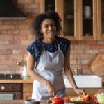 Joyful Young Afro American Lady Cut Vegetable Salad For Lunch