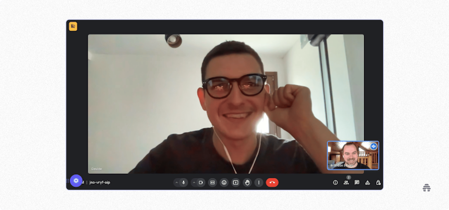 Two people participate in a video call using an online meeting platform, with one person smiling and wearing glasses in the main view and another visible in a smaller window, suggesting a friendly or professional conversation.