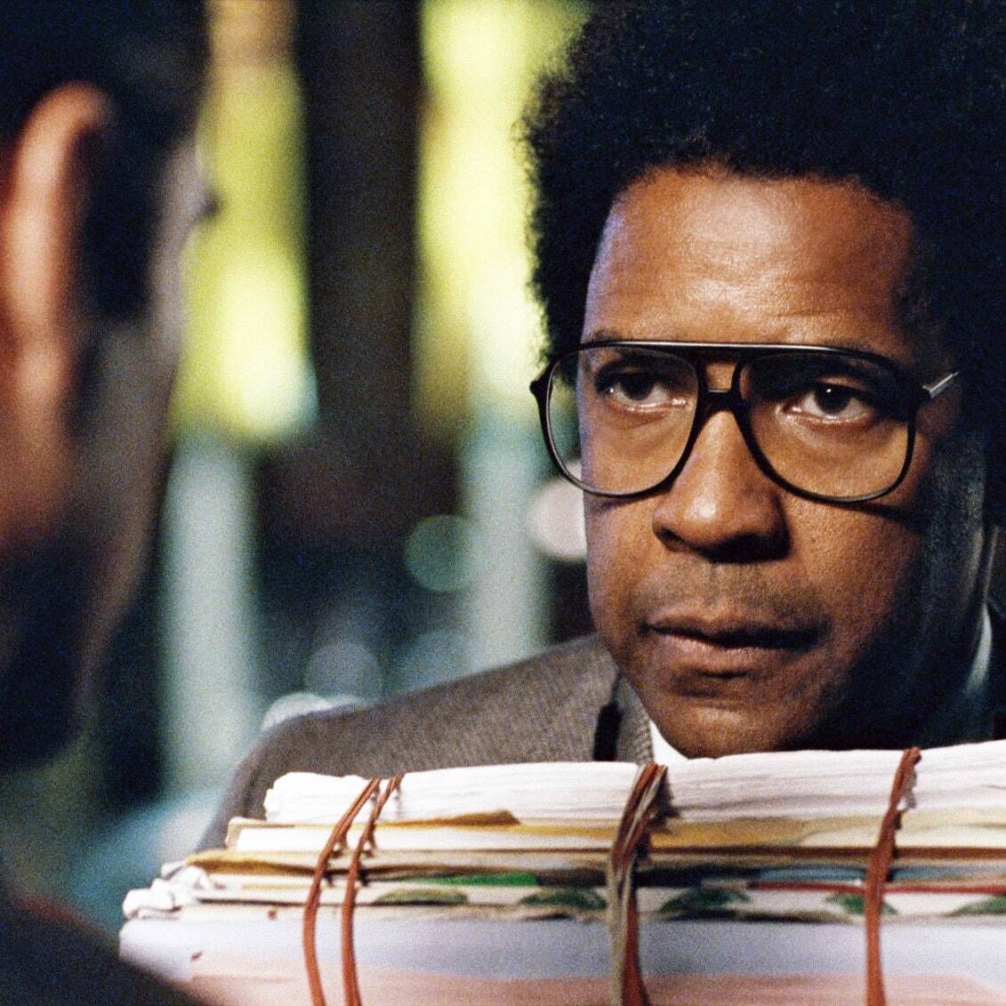  Screenshot of Denzel Washington in Roman J. Israel, Esq., wearing glasses and a dated suit, in a dimly lit office.