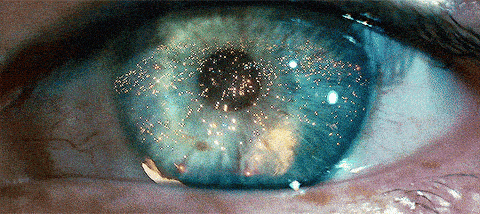 close up of an open eye, with flames reflected in it