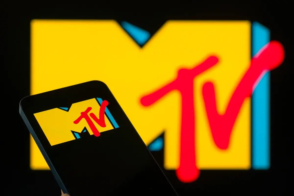 A large icon shows a yellow M with blue sides have red letters that say TV on its side. A phone is shown in front of it that shows the same icon.