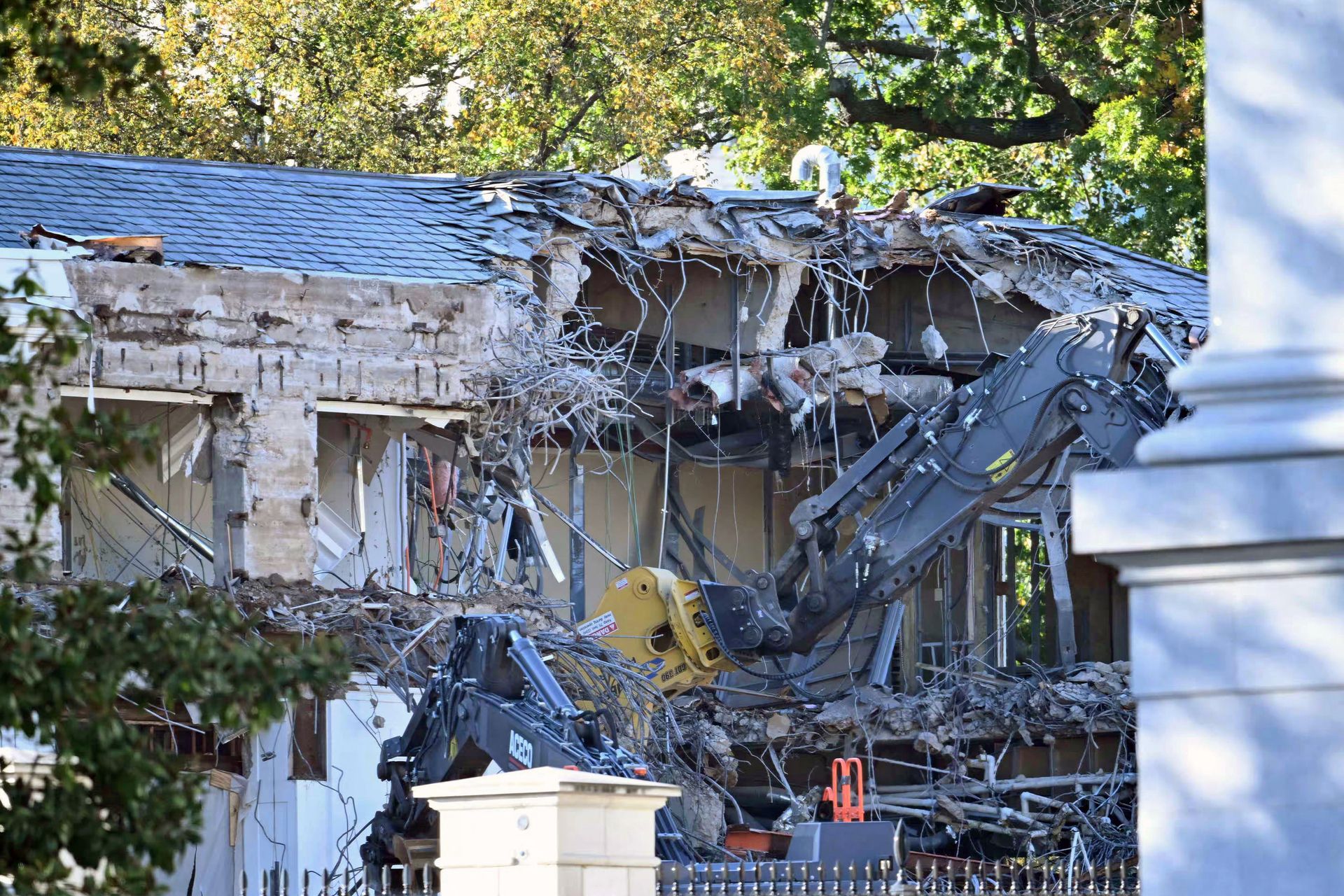 A photo shows construction equipment tearing into a building that has already been partially demolished.