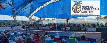 A crowd of people sitting under an awning.