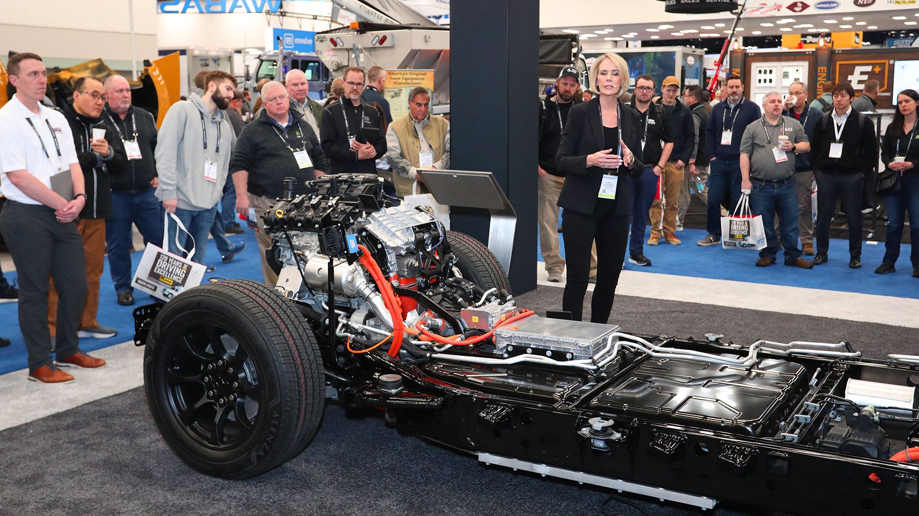 Ram engineering team presenting new chassis cab updates during Work Truck Week, showing frame layout, wiring, and powertrain components to fleet professionals.