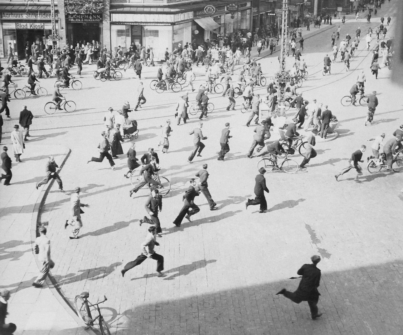 Danes running away from Gestapo officers in Aarhus, Denmark, during increased unrest following German crackdowns on resistance groups within the country.