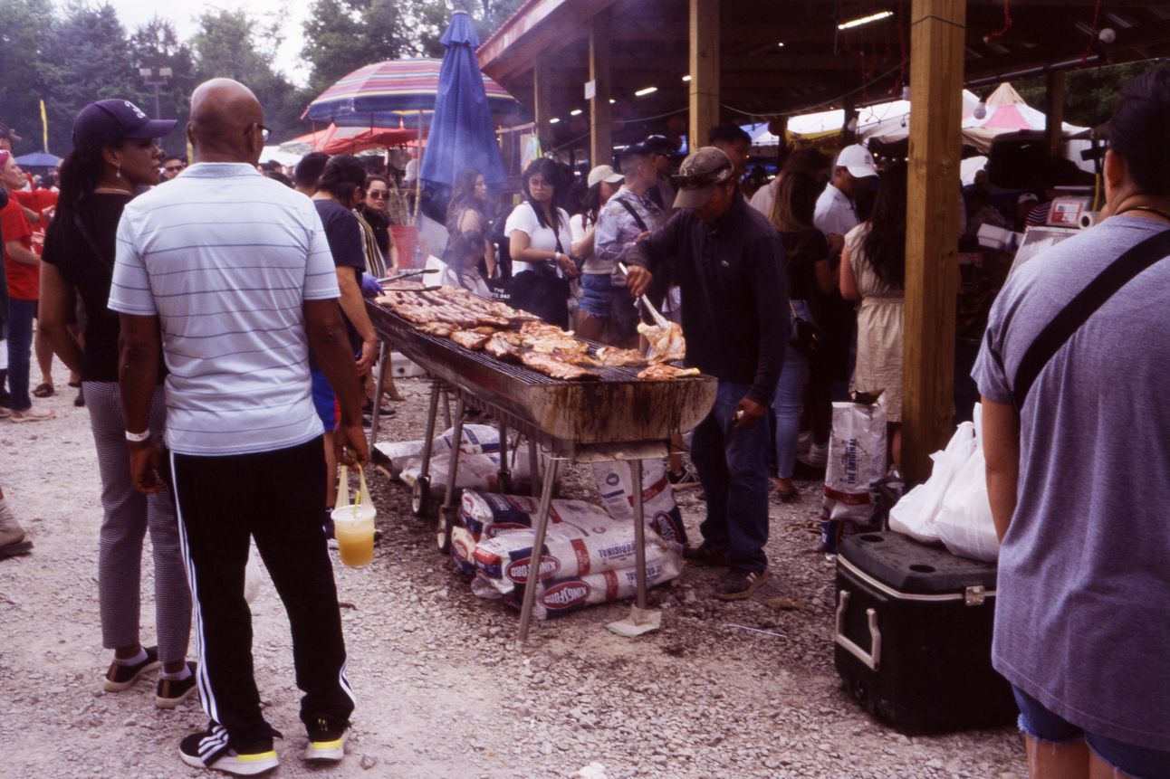 A african american couple inspect a vendor's Lao BBQ.
