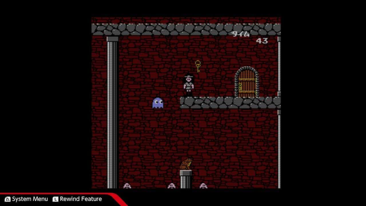 A screenshot from The Quest of Ki, captured on the Nintendo Switch, that shows the blue Pac-Man ghost, Inky, floating near Ki, who has collected the key that opens the exit door.