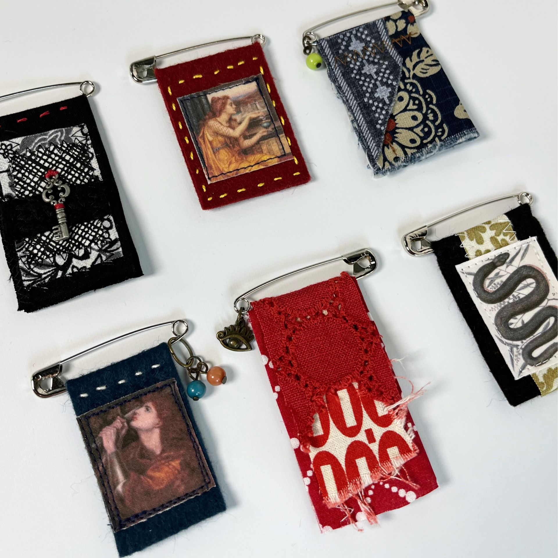 Pin charms are fabric banners attached to large safety pinss