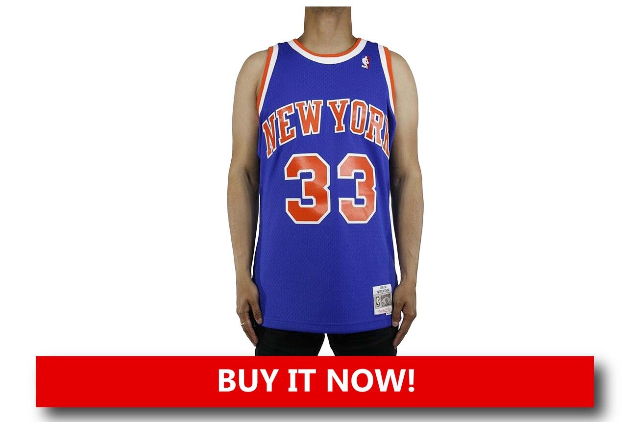  New York Knicks Mitchell & Ness Patrick Ewing Jersey A classic orange and blue Mitchell & Ness jersey featuring Patrick Ewing’s No. 33, laid flat to highlight its retro design, premium stitching, and 1990s Knicks nostalgia.