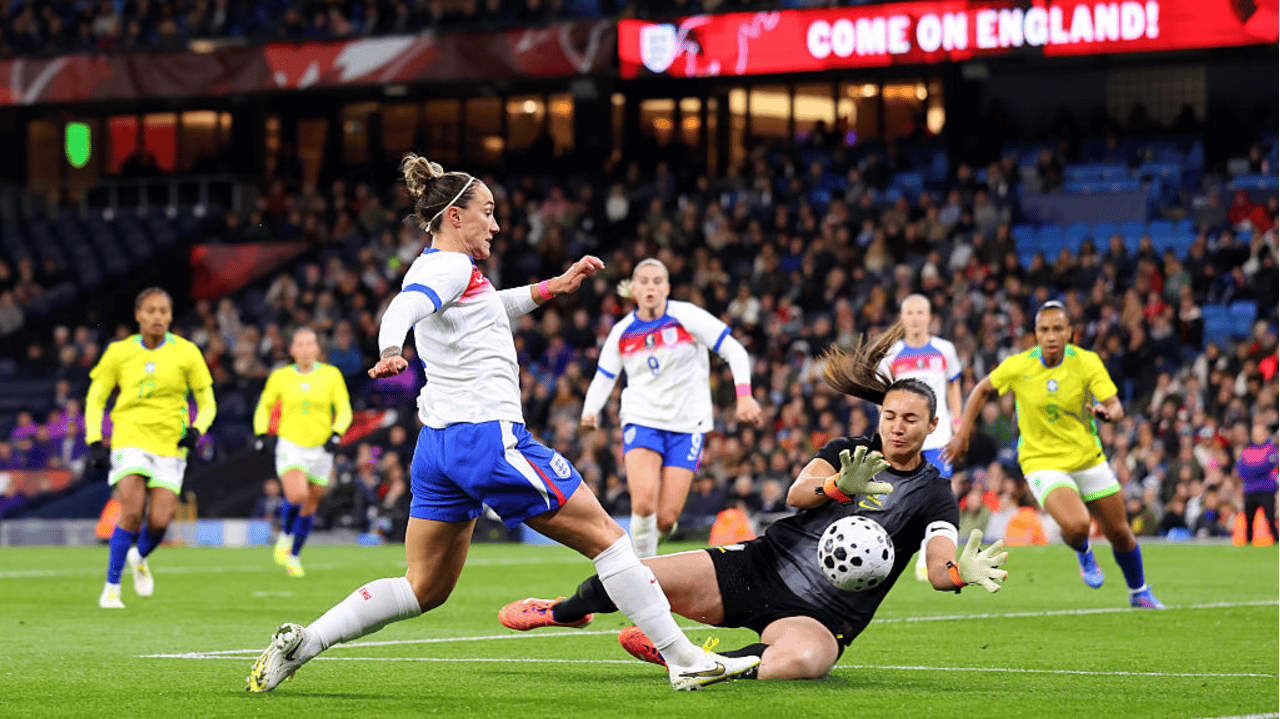 Lucy Bronze of England shoots whilst under pressure from Lorena of Brazil during the Women's international friendly between England and Brazil at City of Manchester Stadium on October 25, 2025 in Manchester, England.