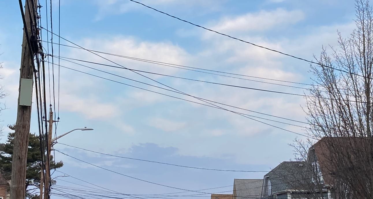 clouds with soft edges behind criss-crossing power lines