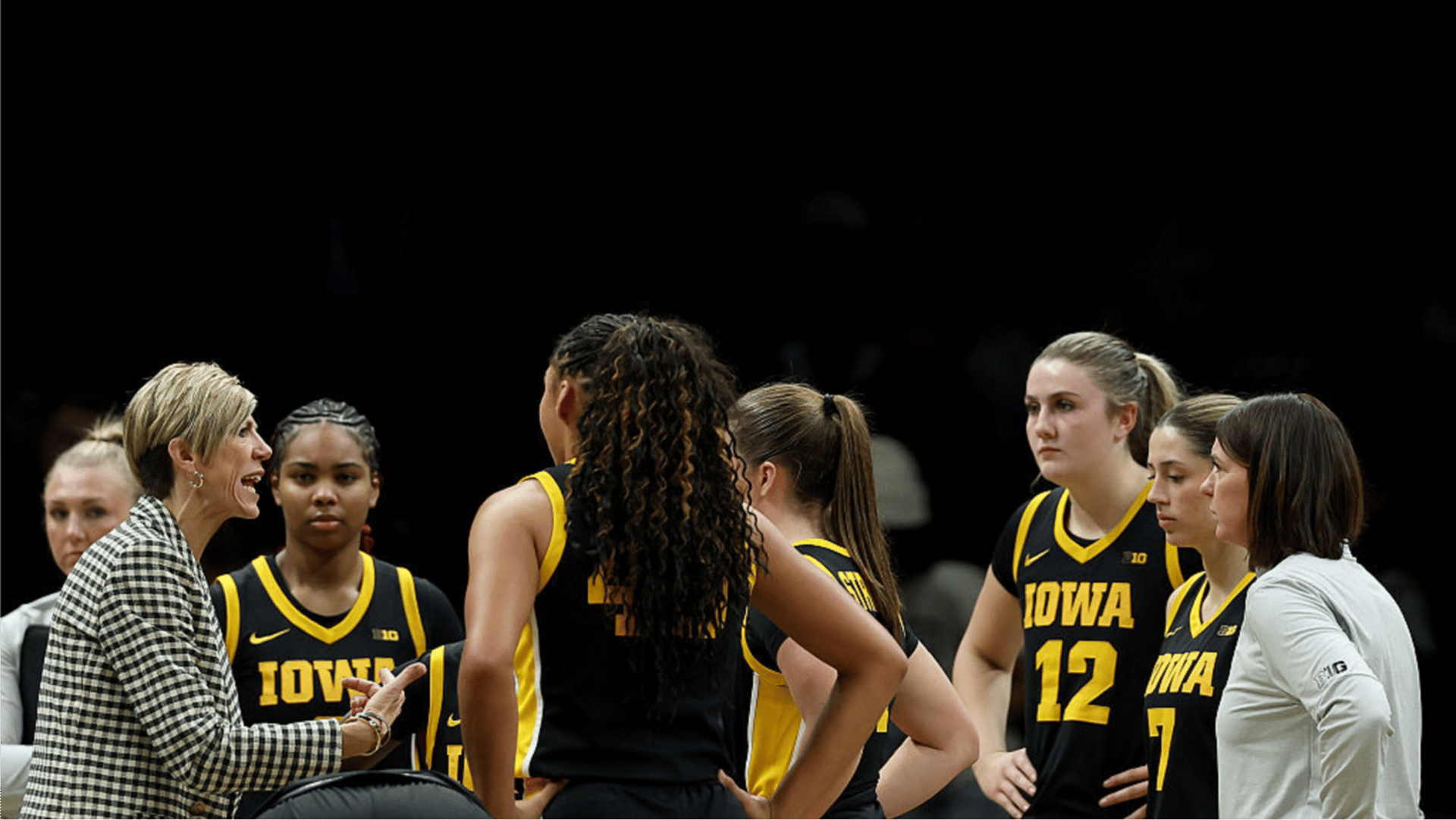 Head coach Jan Jensen of the Iowa Hawkeyes talks to her team during the 2025 Women's Champions Classic