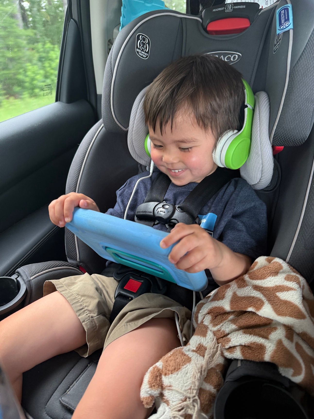 Toddlers boy holding tablet and smiling while watching show 