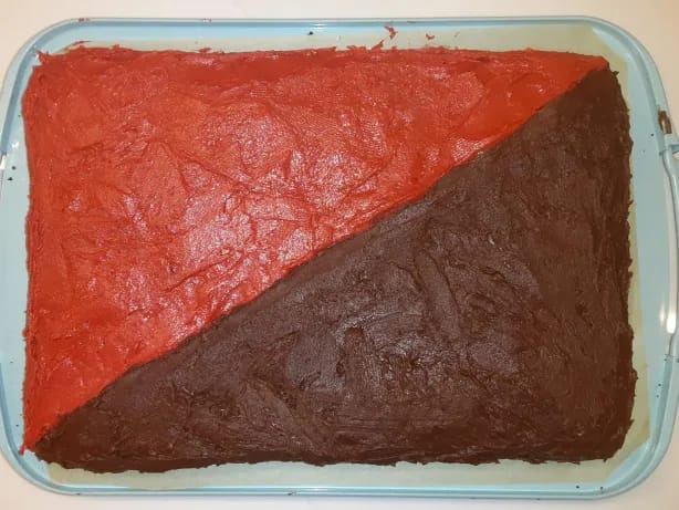 A cake frosted red and black in the anarcho-communism flag pattern