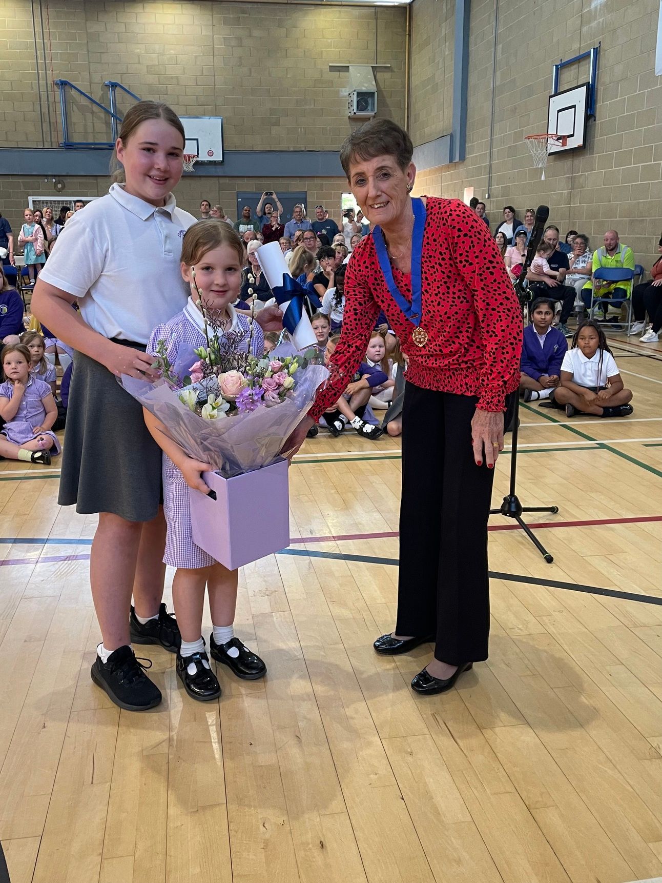 Angela Clear accepting flowers from local students
