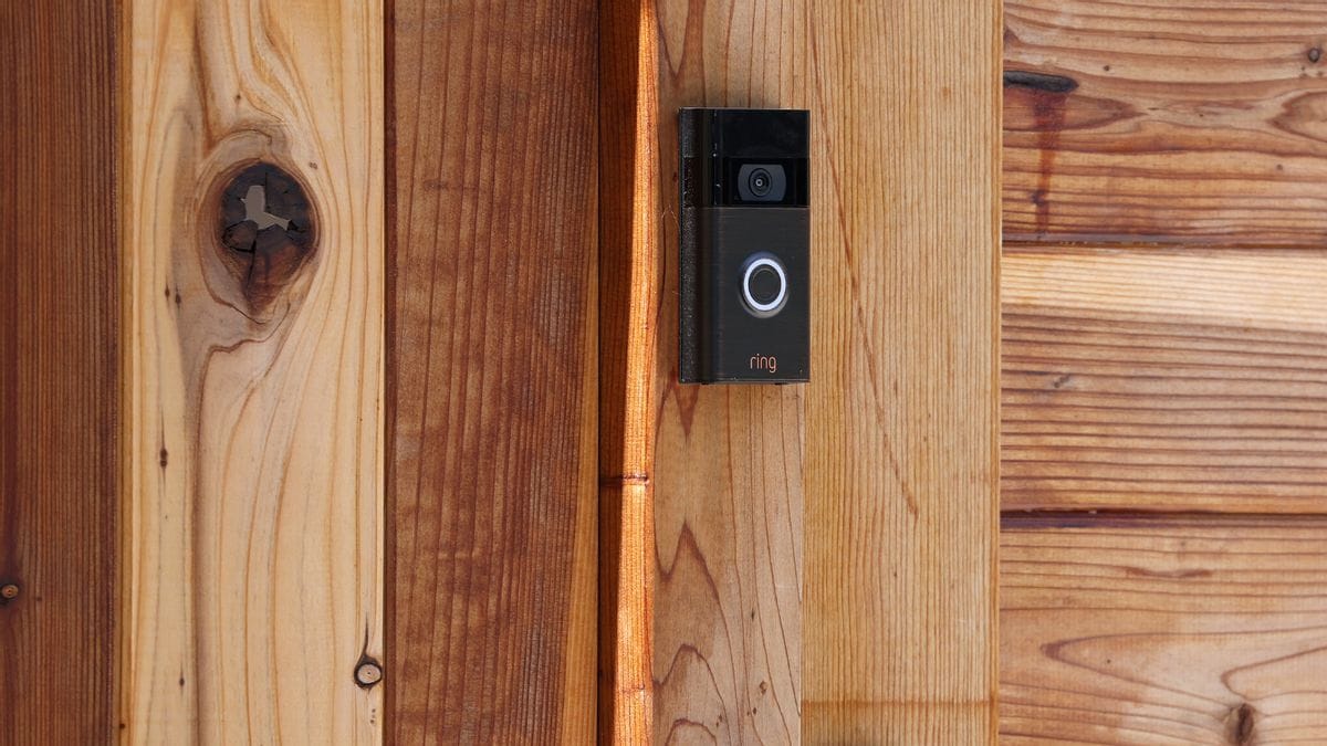 Close up photo of a Ring video doorbell on a house made of wooden planks