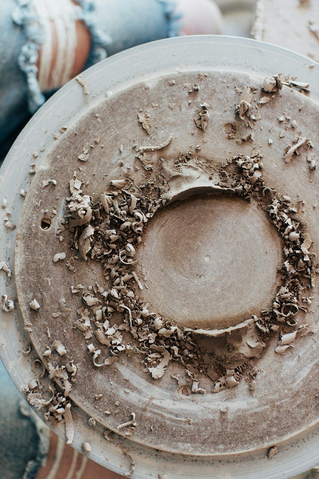 Pottery wheel head with clay shavings on it.