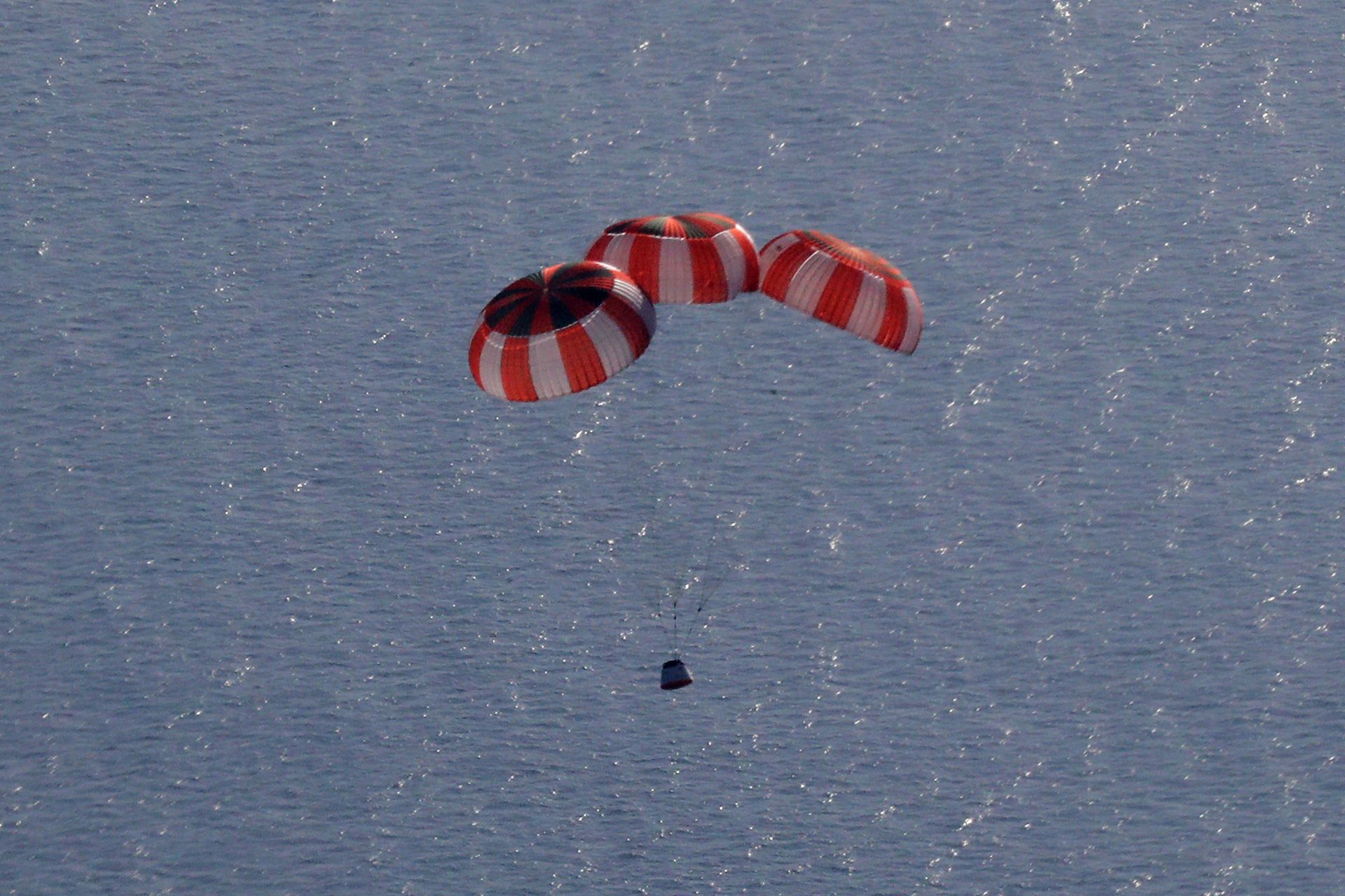 Mid-descent view of the crew module with drogue parachutes deployed, providing initial deceleration in the test of Gaganyaan’s recovery system. The parachute layout mirrors that planned for actual crewed missions.