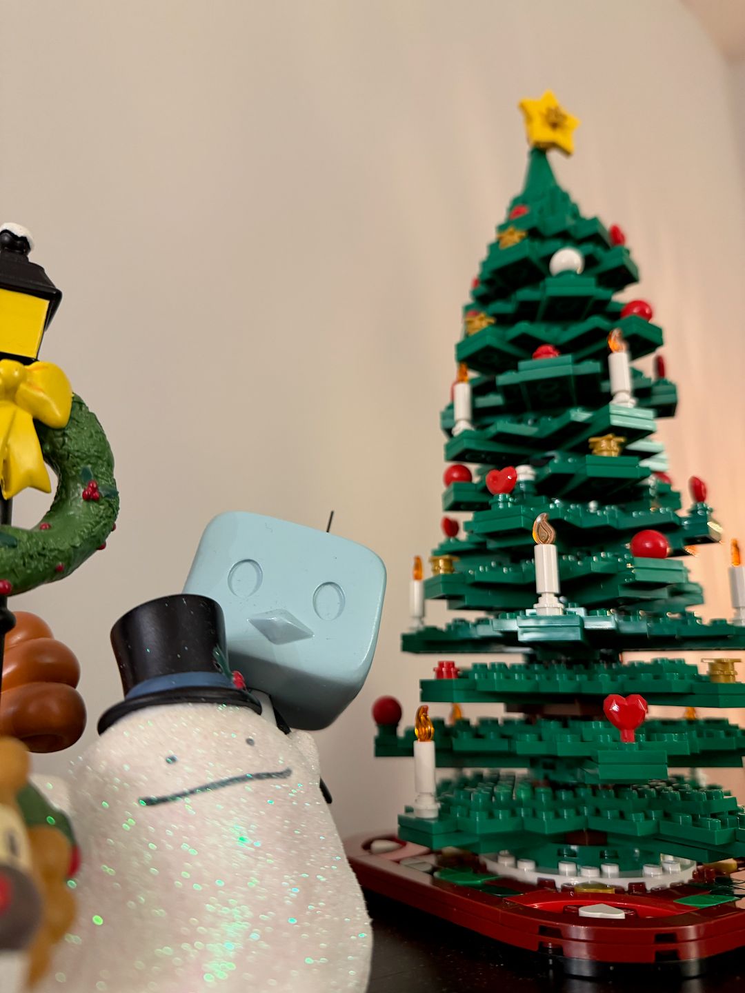 a lego Christmas tree next to a Pokémon Christmas figure with a Ditto made from snow