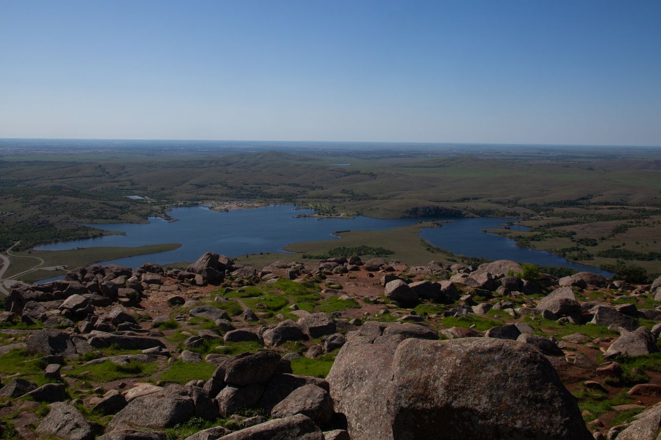 A view from a high point of a lake and the surrounding countryside.