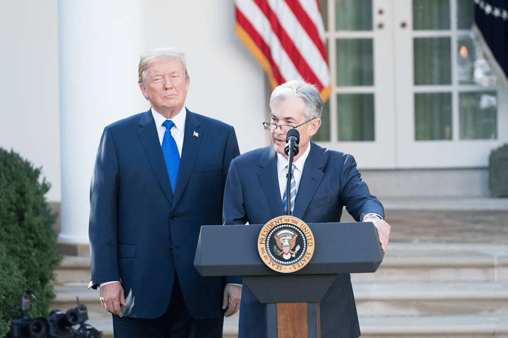 picture of jerome powell behind a podium and donald trump standing behind him