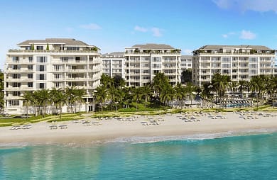 A beach front with many buildings and palm trees.